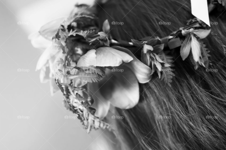 Black and white closeup of flower garland crown on long brown hair 