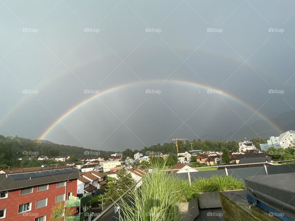 double beautiful rainbow after rain over the city in switzerland