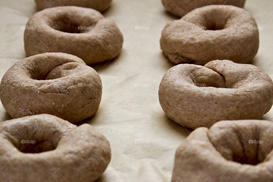 Angled closeup of sourdough spelt and whole wheat dough for bagels on parchment paper