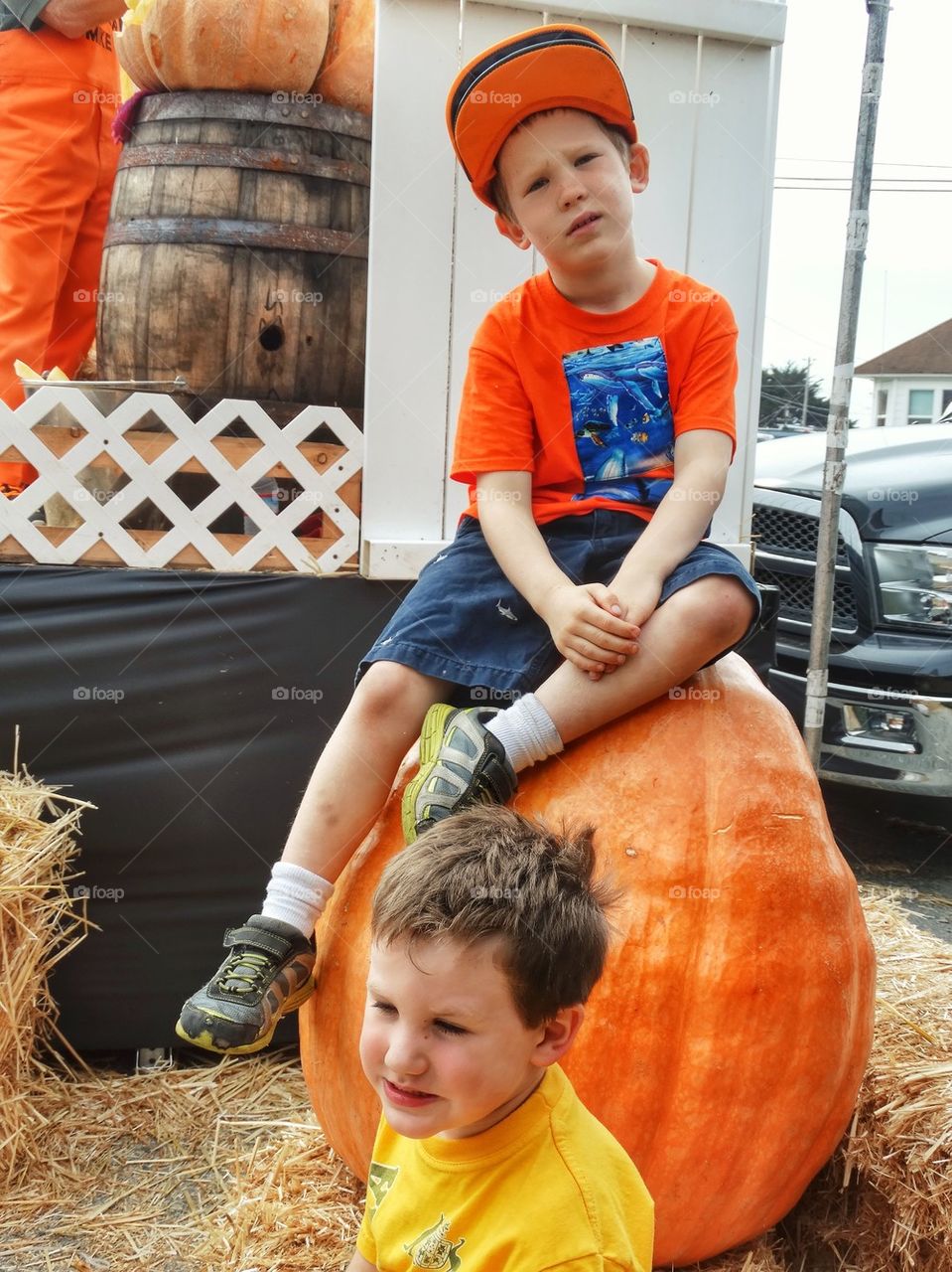 Farm Boys With Giant Pumpkin. Halloween Harvest Festival With Giant Pumpkins
