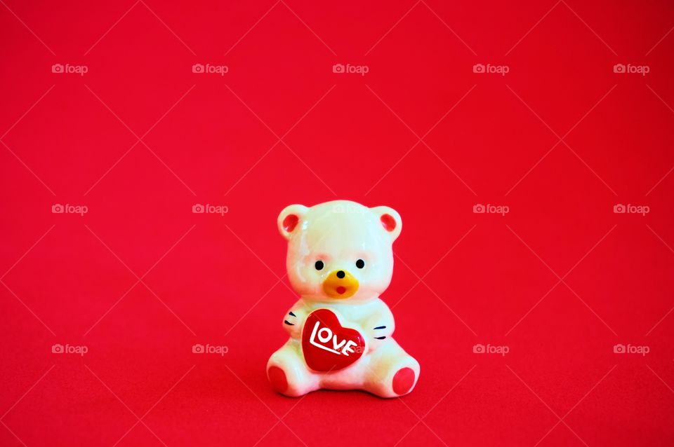 Teddy bear isolated on red background 