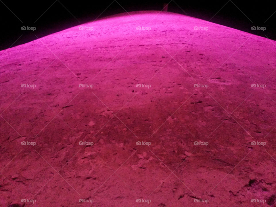 old fortified tower illuminated by pink light - view from below Sardinia