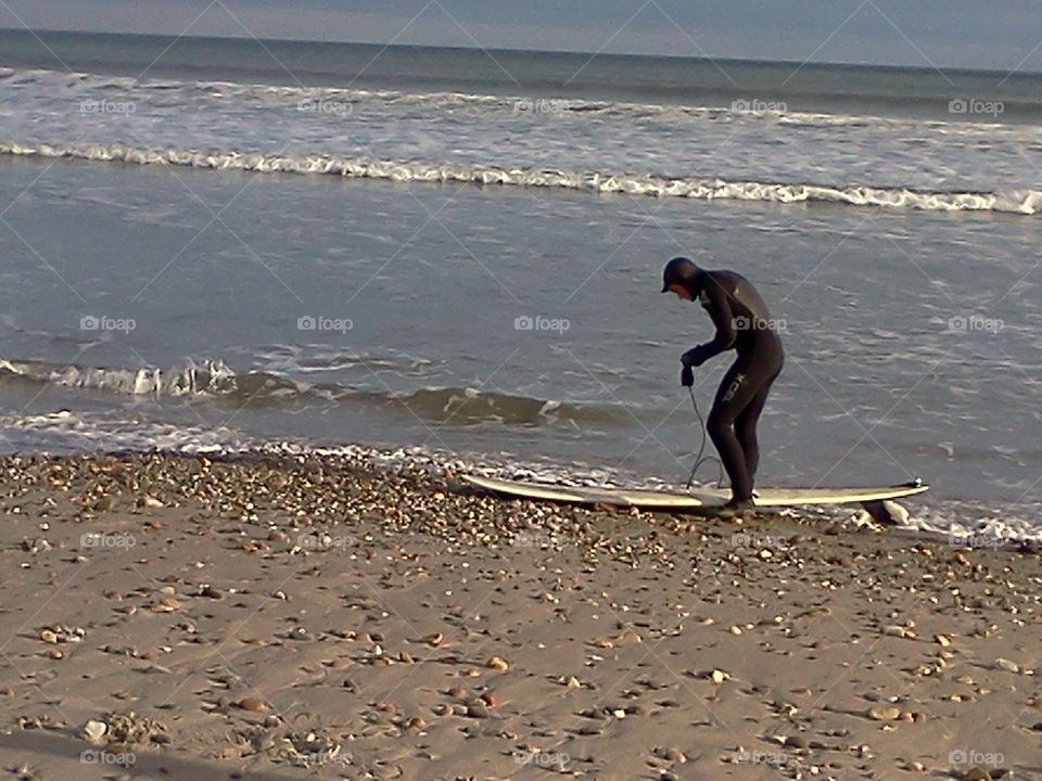 Surfer wearing a wetsuit about the go surfing in December in Rhode Island.