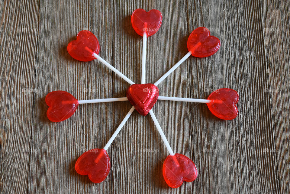 Heart shaped lollipops on a wood background