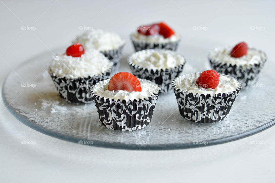 Close-up of a plate of decorated cupcakes on a plate indoors