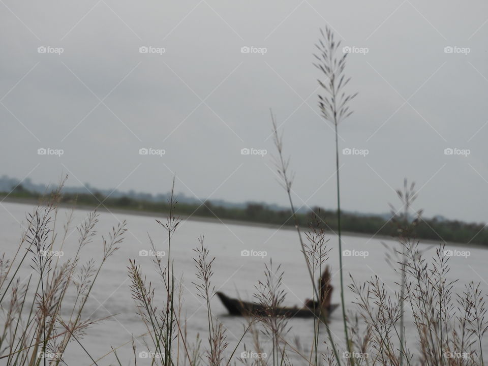 focous on the near object  and try something new .. boat men in  river  busy in his work and i watching him do his work .