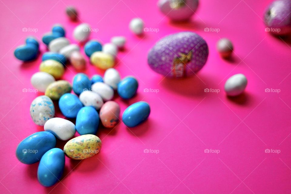 Candy Easter eggs on a bright pink background 