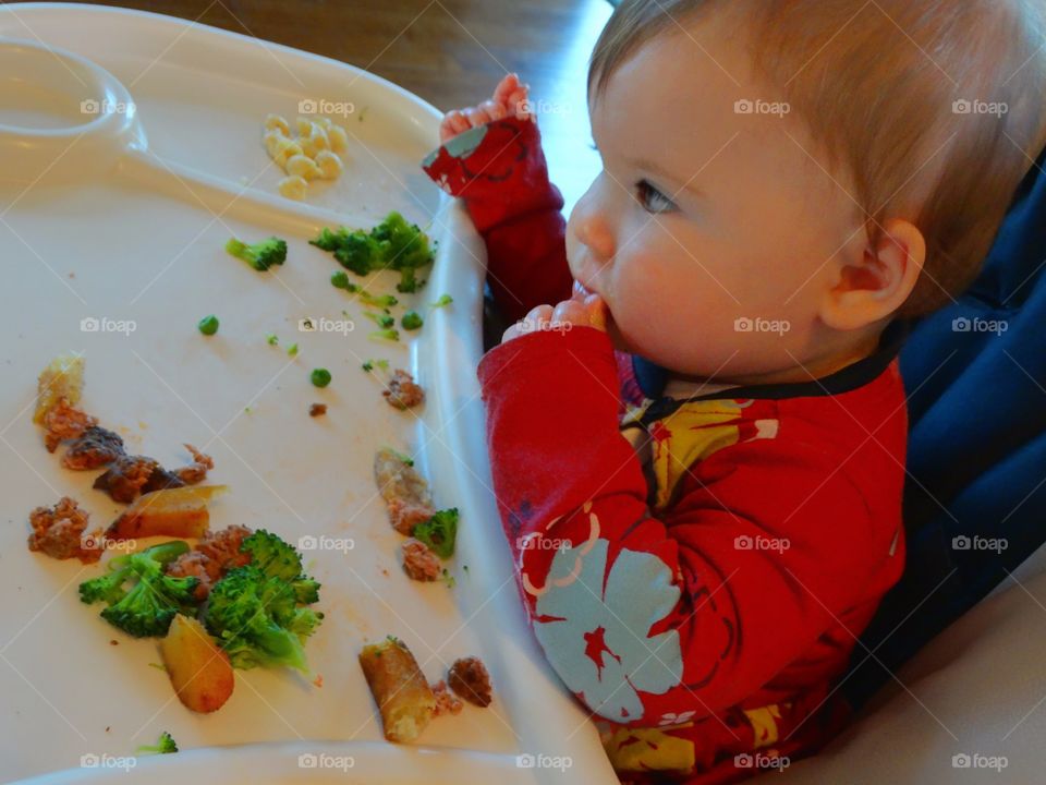 Baby Eating In A Highchair