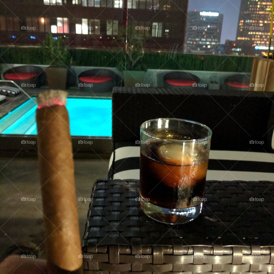 cigar and alcohol on a rooftop at night