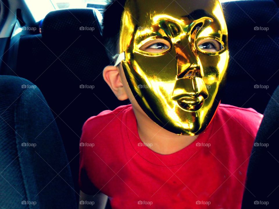 young kid wearing a gold face mask