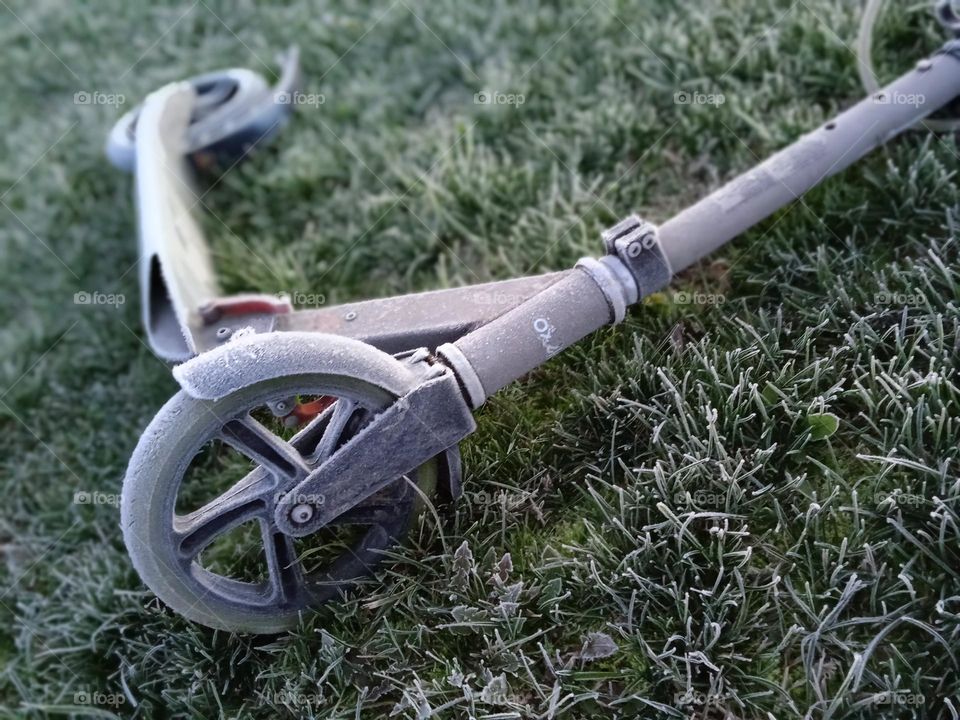 Forgotten scooter in the frosty morning
