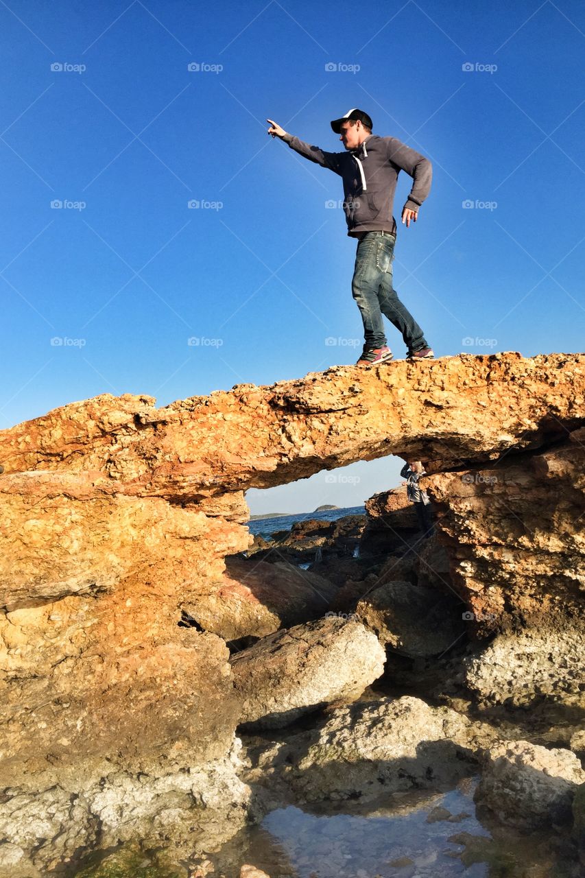 Man dancing on a bridge of rocks