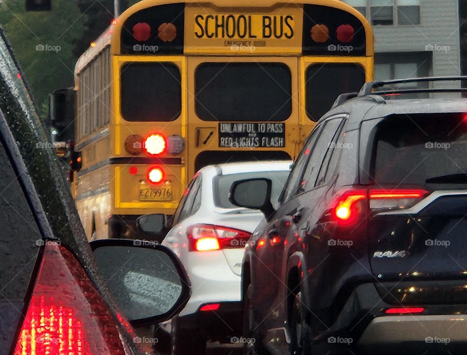 cars and school bus stopped at a traffic light during early morning commute in Oregon