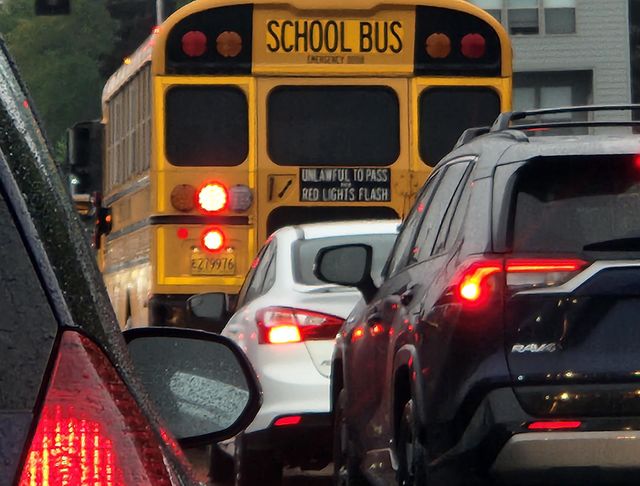 cars and school bus stopped at a traffic light during early morning commute in Oregon
