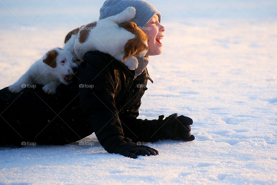 Small boy playing with dog in snow