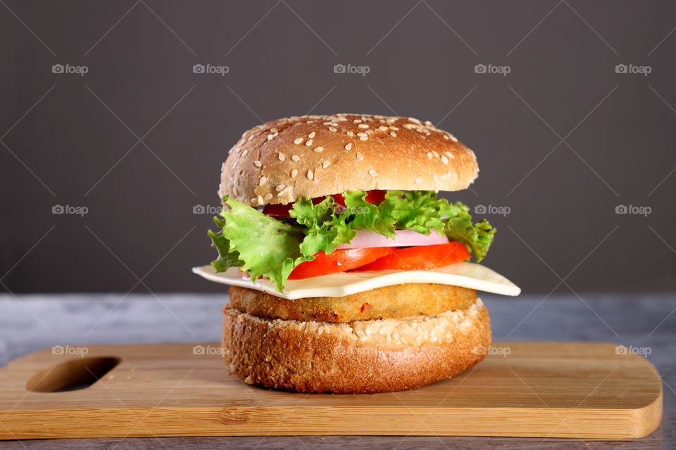Fresh fast food burger on a wooden board