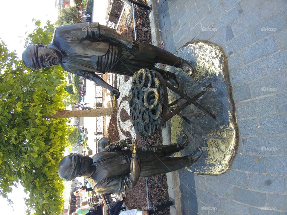 statue of man selling traditional turkish simit to a child