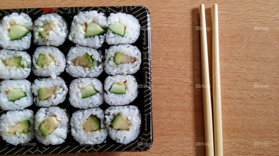 Delicious vegetarian sushi roll with chopsticks.