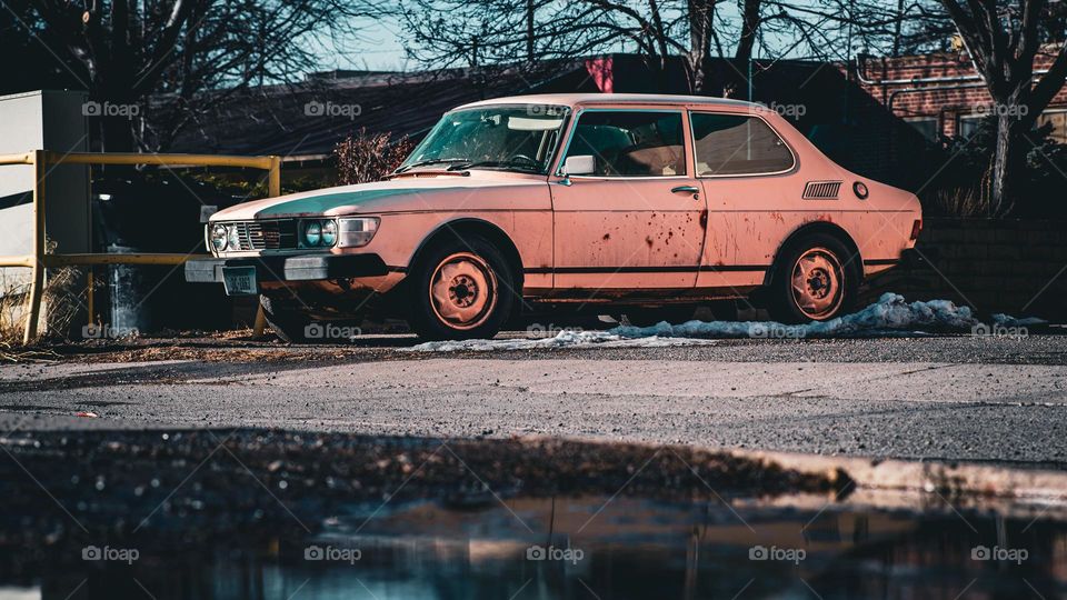 Old car and puddle reflections.