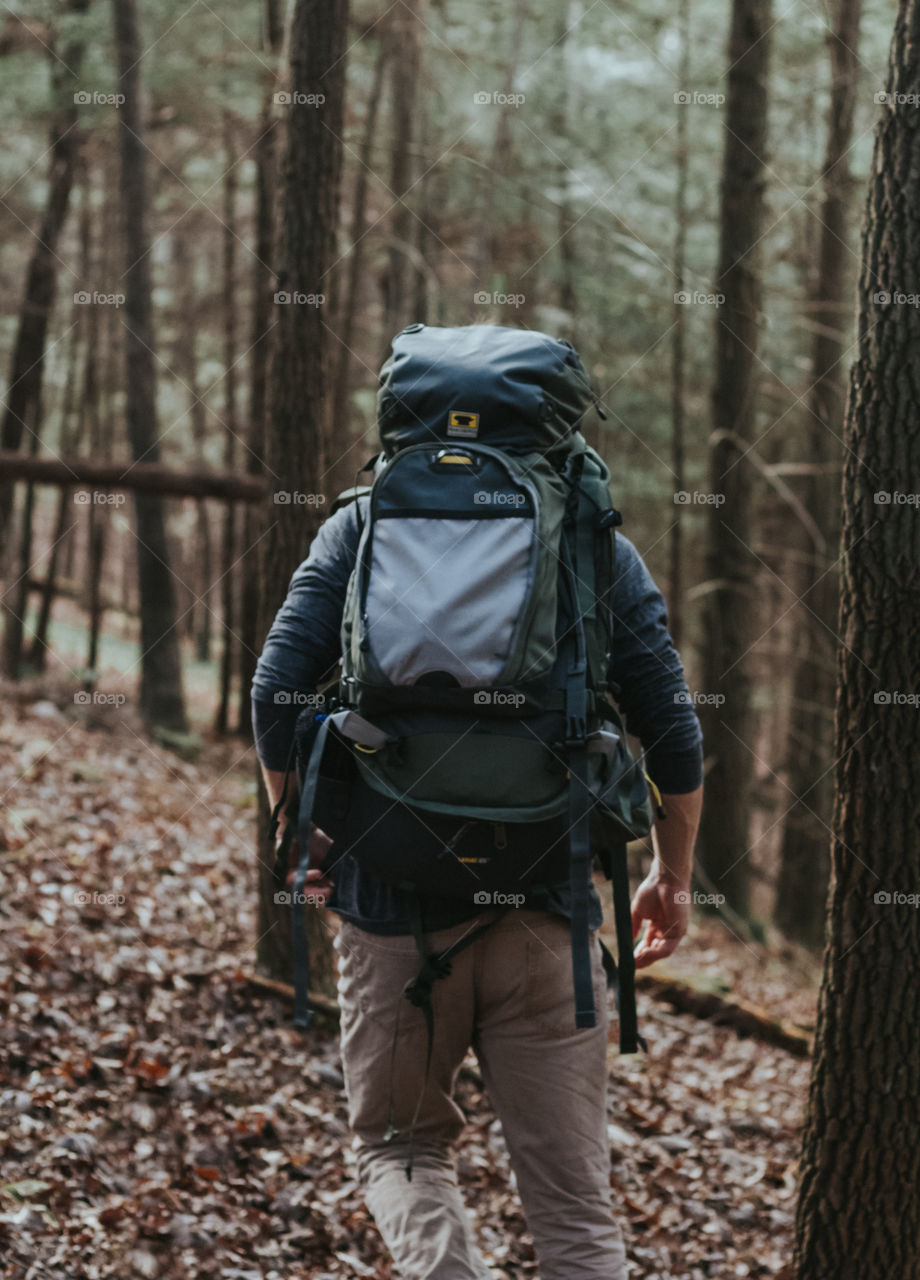 Man Hiking Through Woods With Backpack