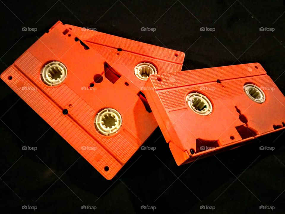Orange audio cassette on black background