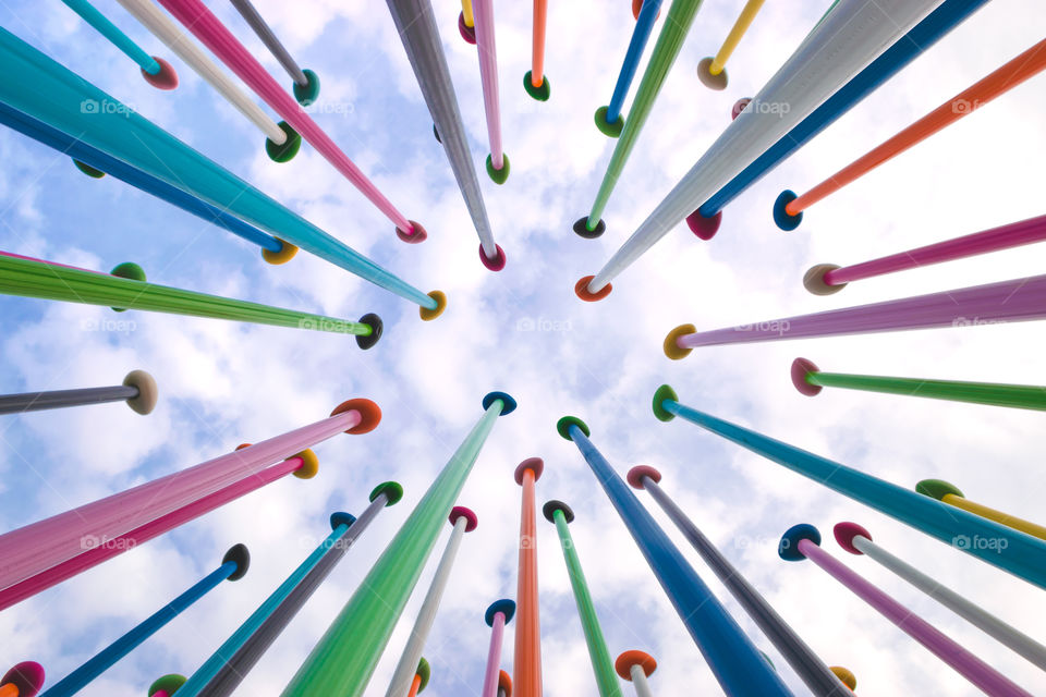 Low angle view of an artistic work (a series of colored poles) in the CityLife district in Milan, sky with clouds