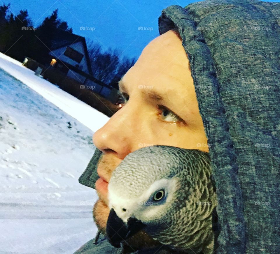 Close-up of a man with grey parrot