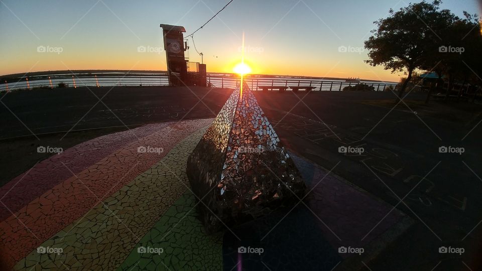 Pyramid of mirrors with the sun rising at the top