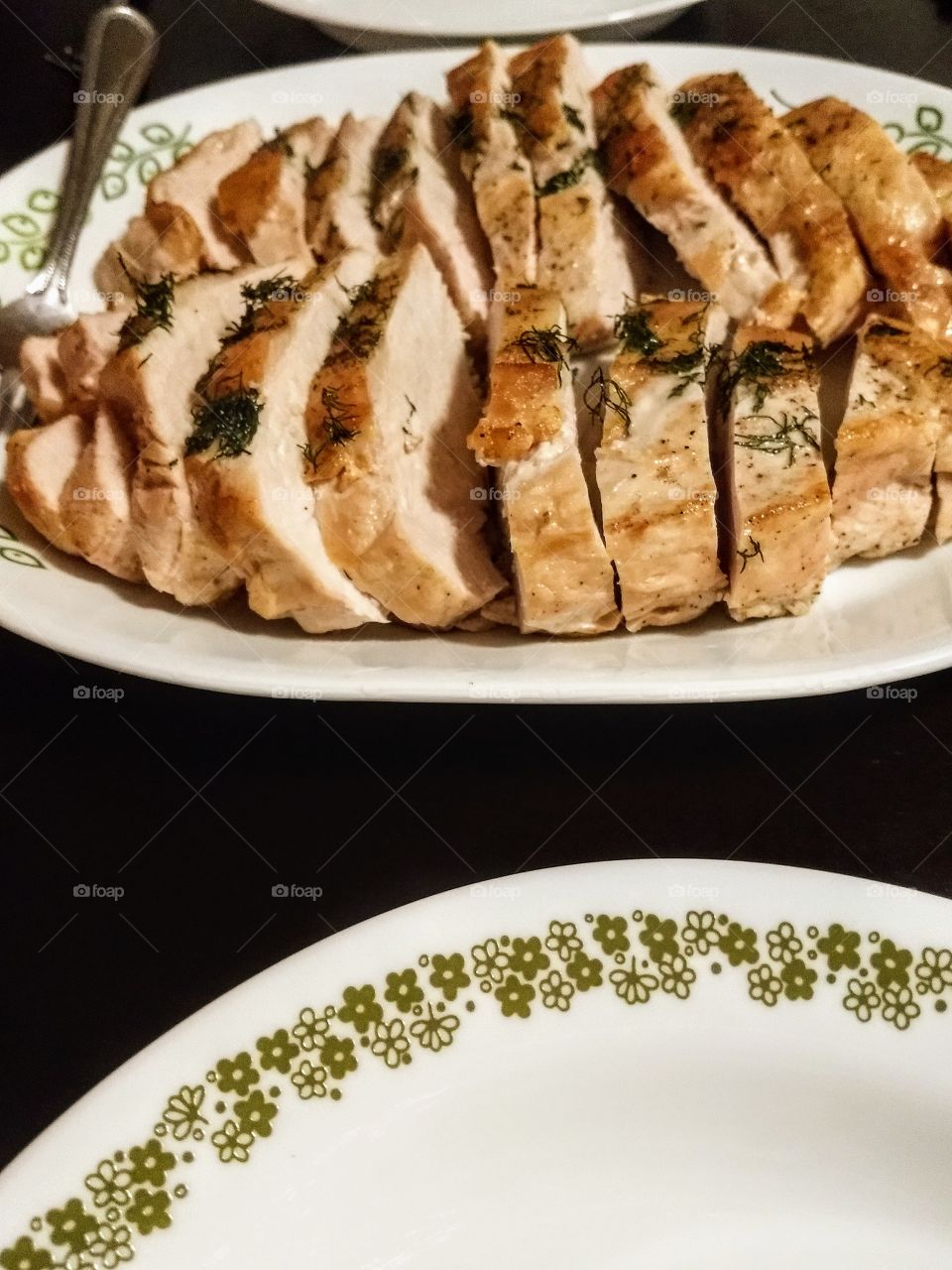 platter of sliced roast turkey breast with dill for holiday meal Thanksgiving or Christmas