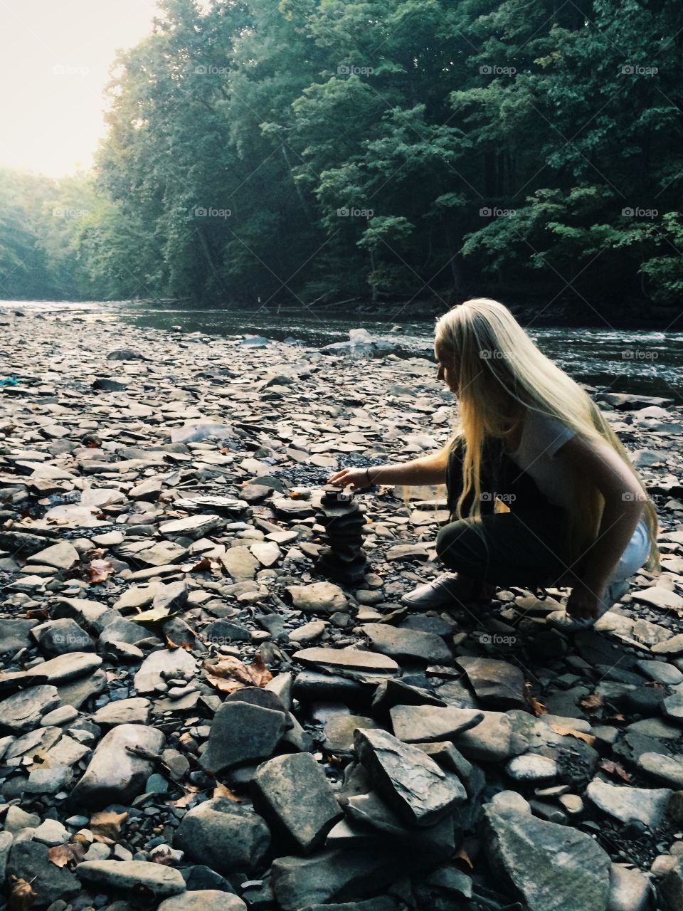 Blonde woman stacking stones