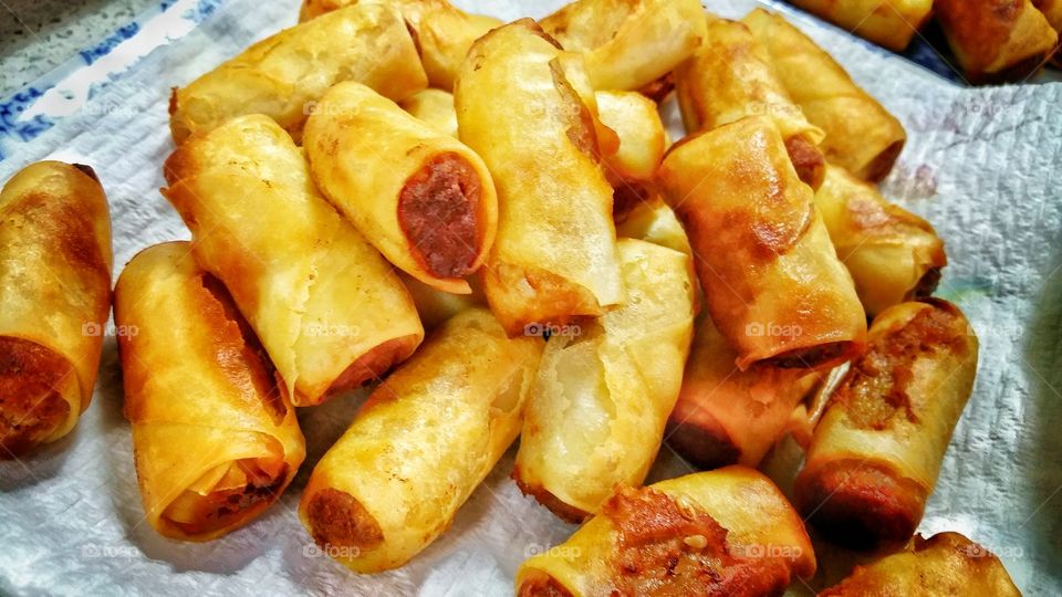 Homemade Chinese mini spring rolls - pastry usually filled with a combination of vegetables and meat before deep frying till golden brown in color.  The finished rolls are allowed to rest a little prior to consumption.