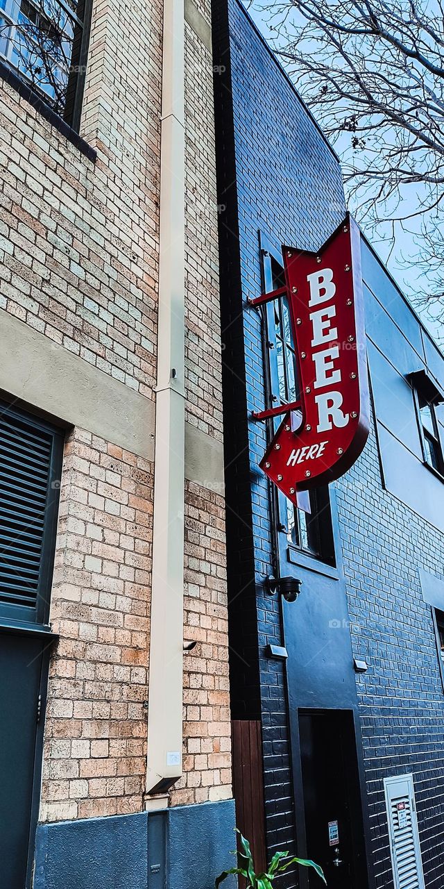 Red beer here arrow sign on an old brick building in Brisbane Australia