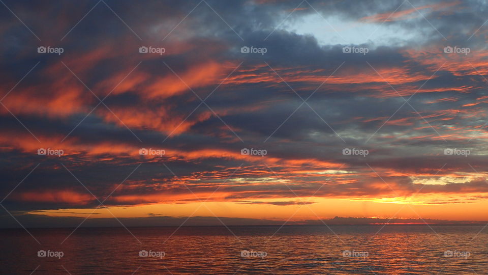 Striking fiery clouds on a blue gray gold orange and red sunset