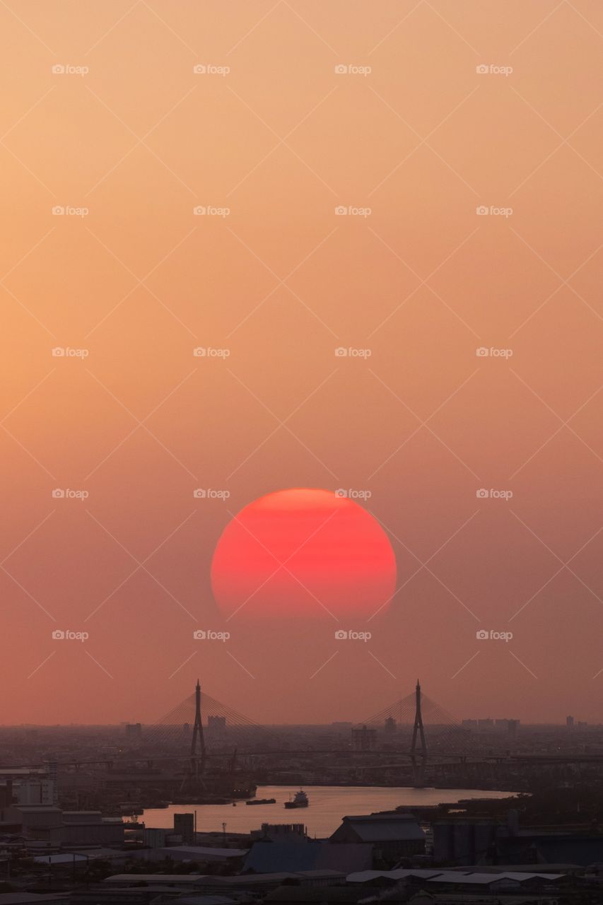 Big sunset behind landmark bridge in Bangkok Thailand