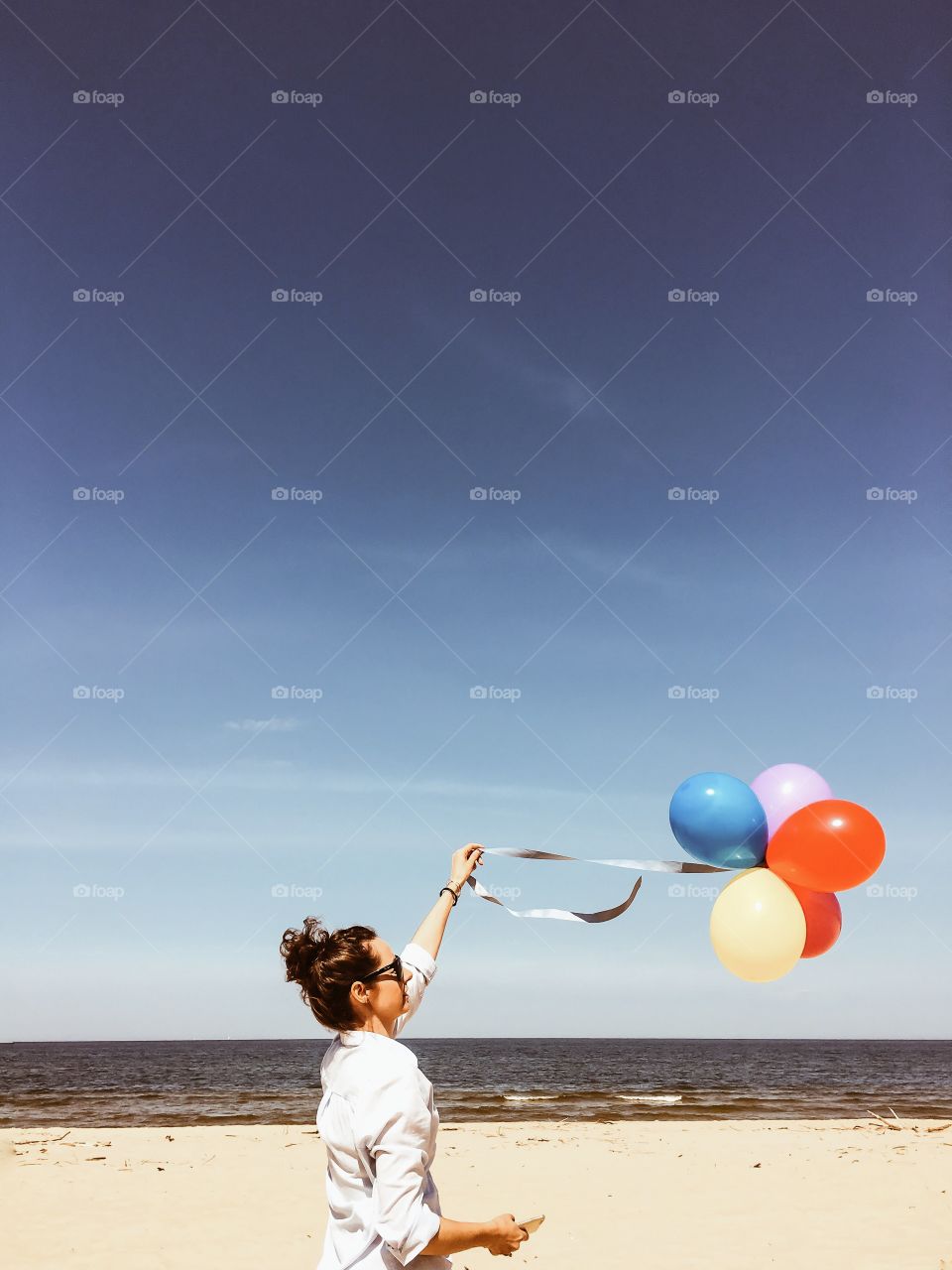 Young woman holding balloon in hand