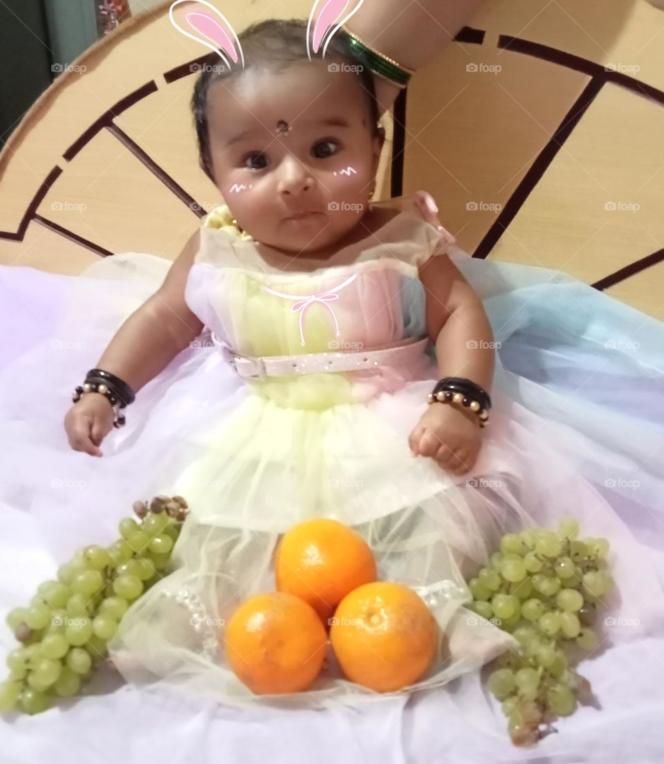 i am cute, happy 😊 and healthy  baby, wearing new dress 👗 i feels very happy because, this beautiful fruits having my arround!!