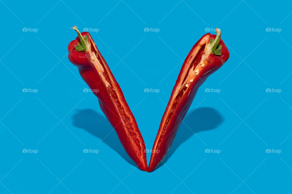 Chilli pepper sliced on half on blue background