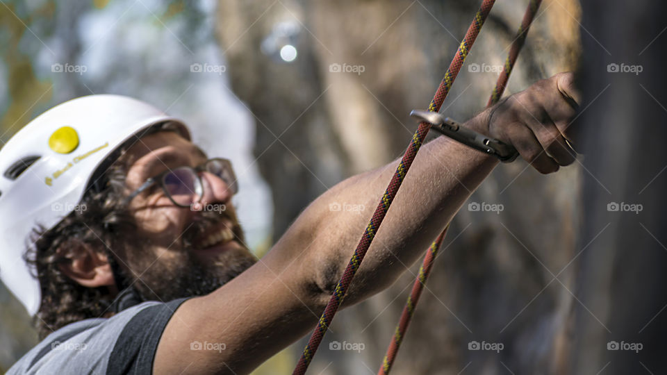 Smiling Sportman climbing a wall