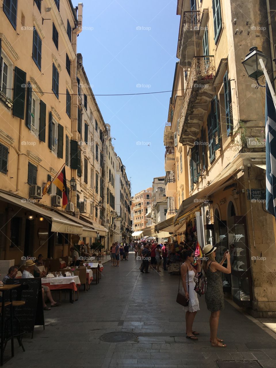 Girl stopping to take photo in the streets of Corfu Town, Greece