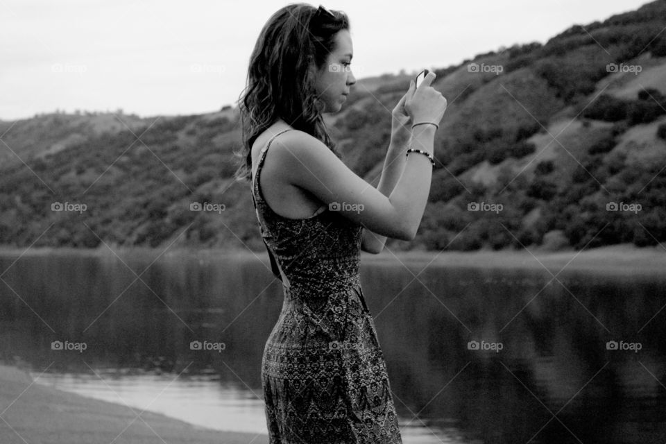 Woman taking photograph in lakeside