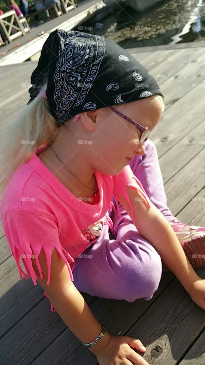 Girl on the docks. A little girl sitting on the small docks in Hvittingfoss, Norway