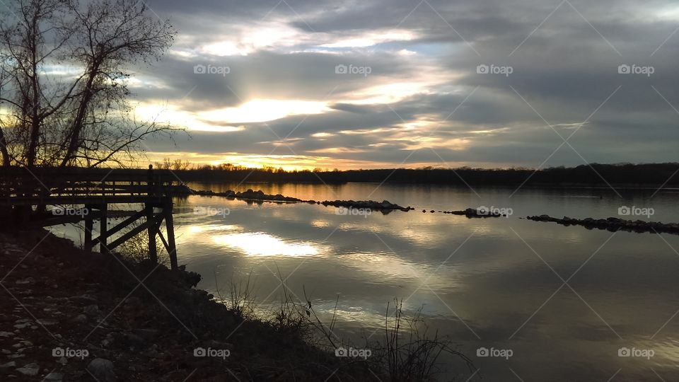 Reflective view of river at sunset