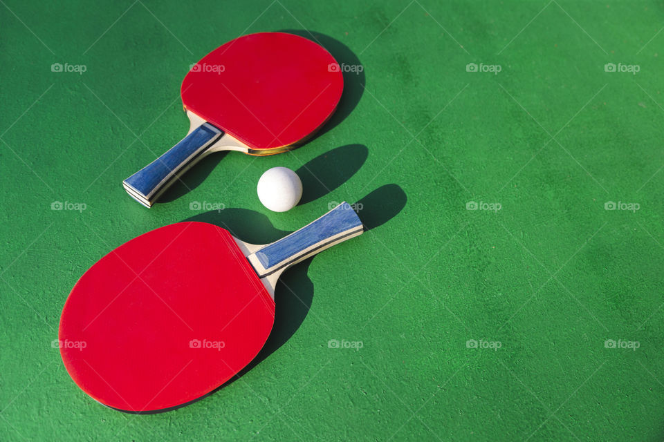 Table tennis red rockets on green table. Color clash.