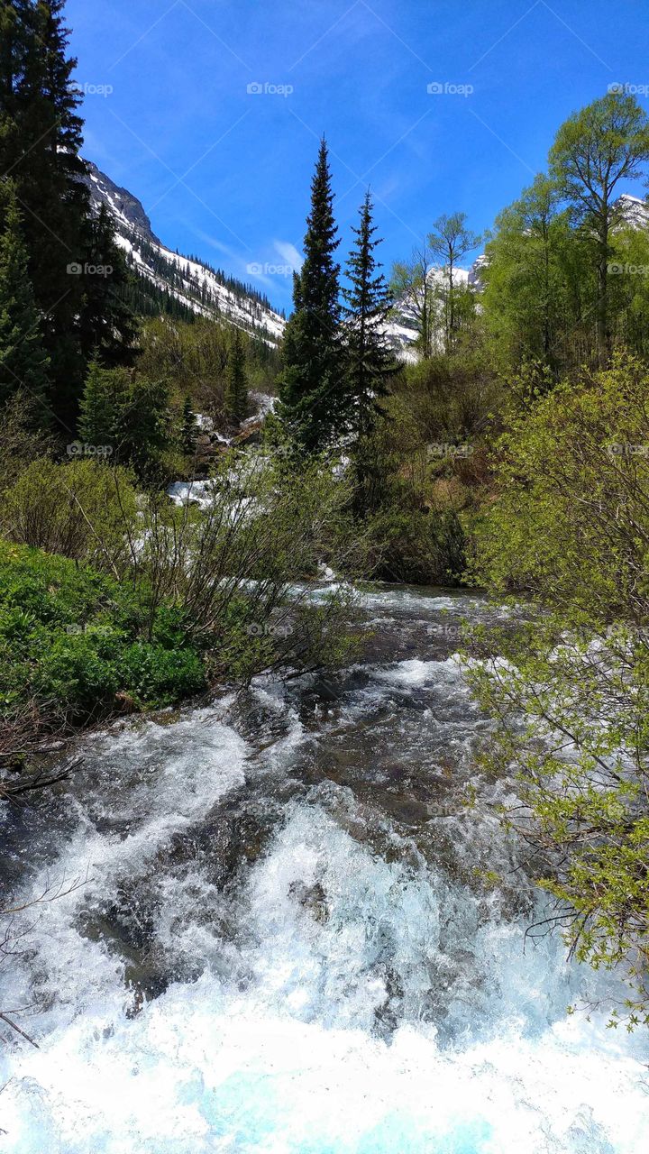 Cascading down from Maroon Bells, Maroon Creek's rapids charge towards the lake below,