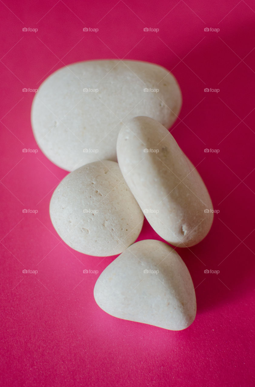 Pile of white rocks on pink background
