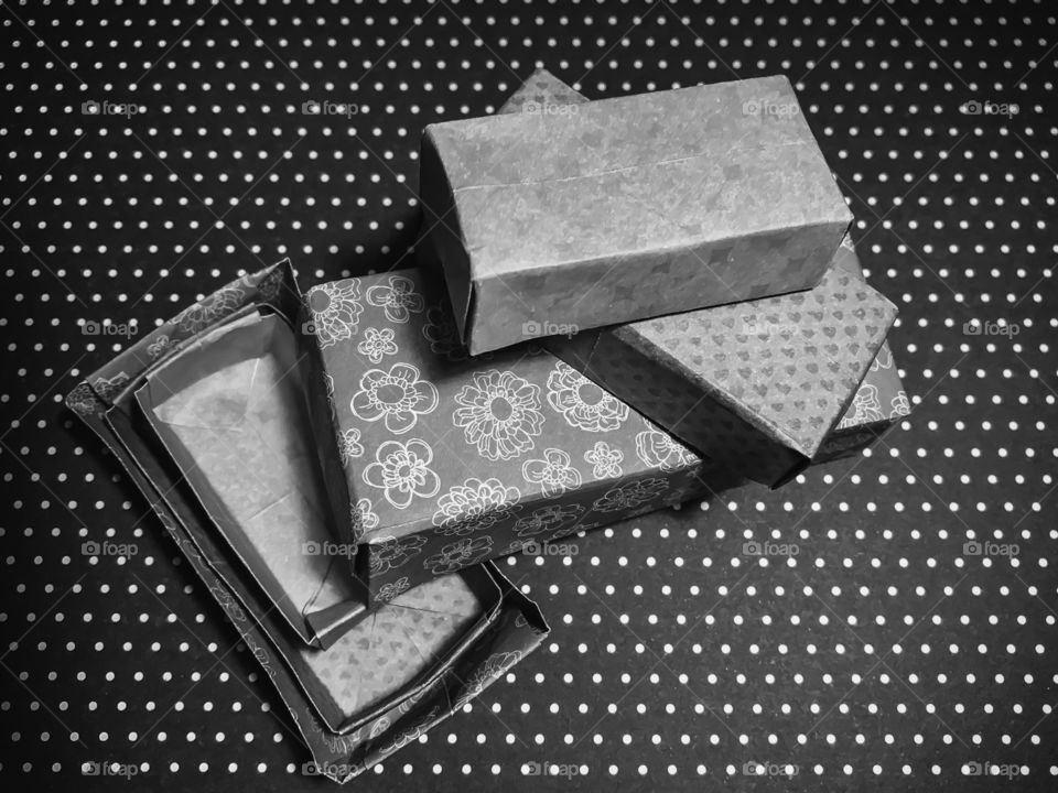 Here are some little hand-made origami rectangular nesting boxes constructed in colourful, patterned paper on a dotted background. The differing shades & patterns of the paper are well demonstrated in the monochrome palette.