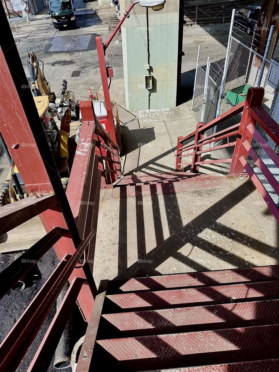 This is the red metal staircase of the “Pulaski Bridge” in LIC, Queens. The orange red of the structures and warm orange glow of the pavement brings with it an overtone of complementary blue in the abstract shadows. 2025. Hypnotic Productions