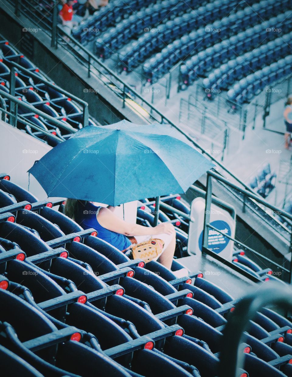 Sports fan in stadium on rainy day 