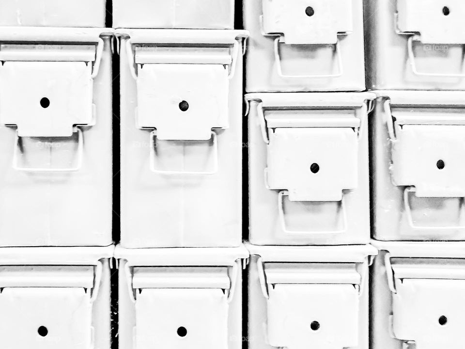 Creative photo: Two sizes of stacked metal ammo cans over exposed creating an interesting design with lines,  shapes  and texture. The over exposure washes out the olive green to a pale white color creating a distinct look.