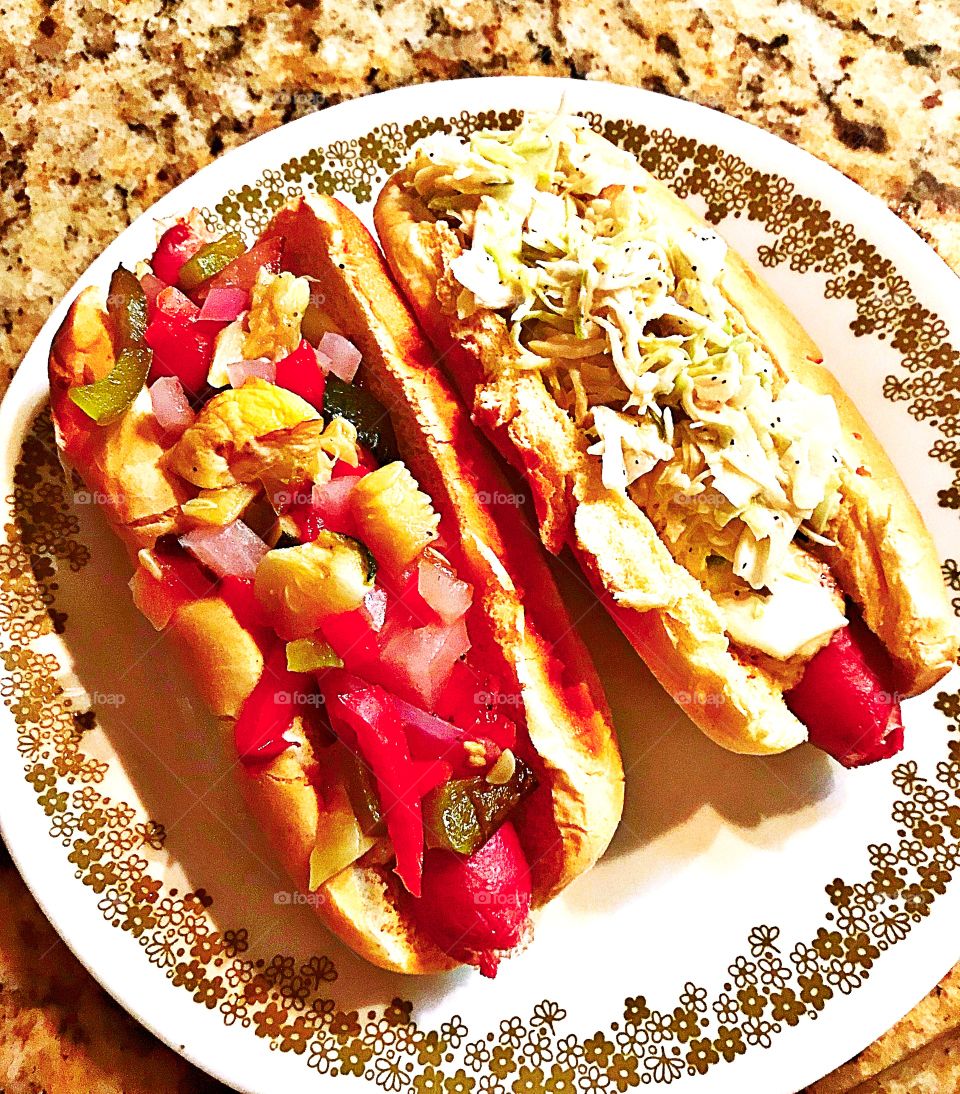 Two all beef hotdogs. One with red onions, sweet red peppers chopped bread and butter pickles, and mustard. One with homemade coleslaw!